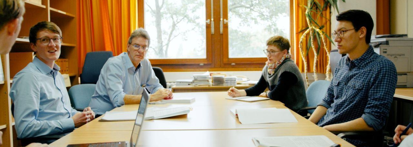 Mehrere Personen sitzen an einem Konferenztisch