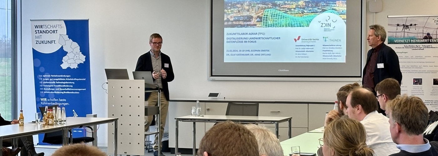 Zwei Männer halten einen Vortrag in einem Konferenzraum