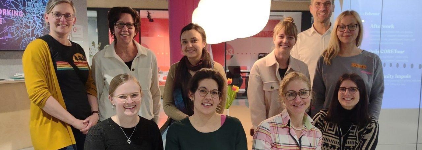 Eine Gruppe von Personen (primär Frauen) blickt in die Kamera