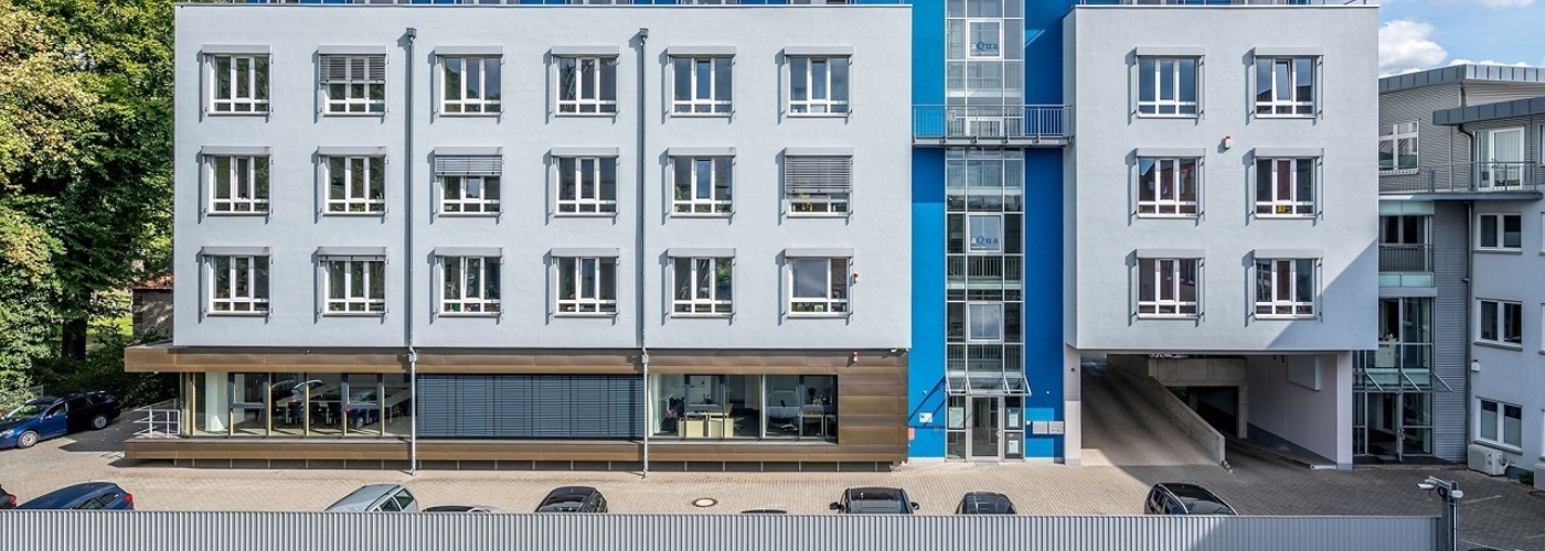Bild eines hellblauen vierstöckigen Gebäudes.