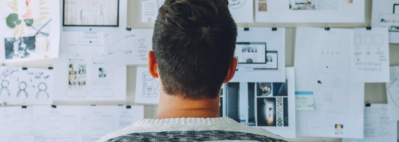 Mann steht vor einer Wand mit Notizen