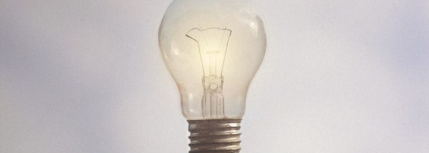 Hand unter einer schwebenden Glühlampe